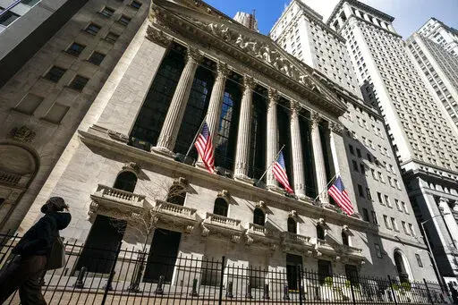 A pedestrian walks past the New York Stock Exchange, Monday, Jan. 24, 2022, in New York.  Stocks are falling in early trading on Wall Street Friday, April 29, putting major indexes back into the red for the week after several sharp moves both up and down.  (AP Photo/John Minchillo, File)
