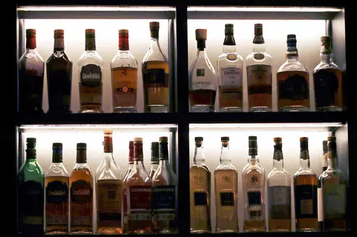 A vast array of single malt scotch bottles are displayed at Wink & Nod, basement-dwelling, speakeasy-like bar, in Boston, on Dec. 10, 2019. In Massachusetts, Democrats and Republicans could find an issue to agree on: letting bars have happy hours. Commonwealth law bans bars and other establishments from having special discounts on beer, wine and liquor. AP VoteCast shows a majority of voters favor the state legalizing happy hour. (AP Photo/Charles Krupa, File)