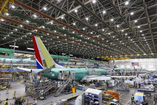Boeing employees work on the 737 MAX on the final assembly line at Boeing's Renton plant, June 15, 2022 in Renton, Wash. The SEC announced Thursday, Sept. 22, 2022, that Boeing Co. will pay $200 million to settle allegations that the company and its former CEO misled investors about the safety of its 737 Max after two of the airliners crashed, killing 346 people. (Ellen M. Banner/The Seattle Times via AP, Pool, File)
