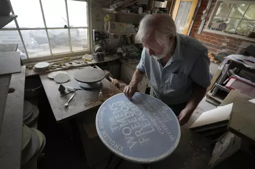 Ned Heywood fettling the glaze on the clay plaque during the making of an English Heritage Blue Plaque, at Heritage Ceramics, The Workshop Gallery in Chepstow, Wales Wednesday, Sept. 6, 2023. English Heritage is preparing to unveil its 1,000th blue plaque, the famous discs that dot the walls of buildings throughout London, marking the places where scientists, artists, politicians and activists have made history. The charity is working to broaden the program to include more women, people from min