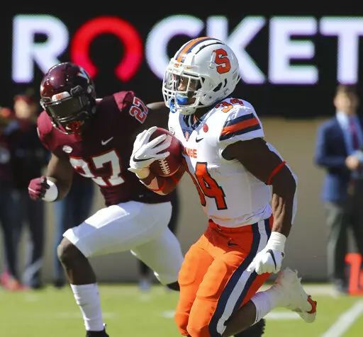 Syracuse running back Sean Tucker (34) runs for a touchdown past Virginia Tech defensive back Armani Chatman (27) during the first half of of an NCAA college football game in Blacksburg Va., Saturday, Oct. 23 2021. (Matt Gentry/The Roanoke Times via AP)