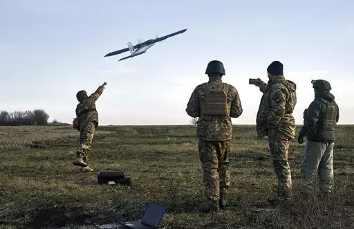 Ukrainian soldiers launch a drone at Russian positions near Bakhmut, Donetsk region, Ukraine, Thursday, Dec. 15, 2022. (AP Photo/LIBKOS)