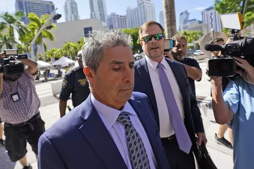Carlos De Oliveira, center, an employee of Donald Trump's Mar-a-Lago estate, arrives for a court appearance with attorney John Irving, at the James Lawrence King Federal Justice Building, Monday, July 31, 2023, in Miami. De Oliveira, Mar-a-Lago's property manager, was added last week to the indictment with Trump and the former president's valet, Walt Nauta, in the federal case alleging a plot to illegally keep top-secret records at Trump's Florida estate and thwart government efforts to retrieve
