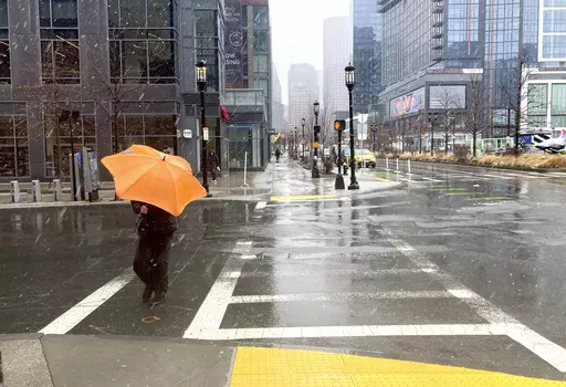 A person braces against the wind as a wintry mix of snow and rain falls in Boston, March 14, 2023. A winter weather system moving through the U.S. is expected to wallop the East Coast this weekend, Saturday, Jan. 6, 2024, into Sunday, Jan. 7, with a mix of snow and freezing rain from the southern Appalachians to the Northeast — although it's too early to say exactly which areas will get what precipitation and how much. (AP Photo/Michael Casey, File)