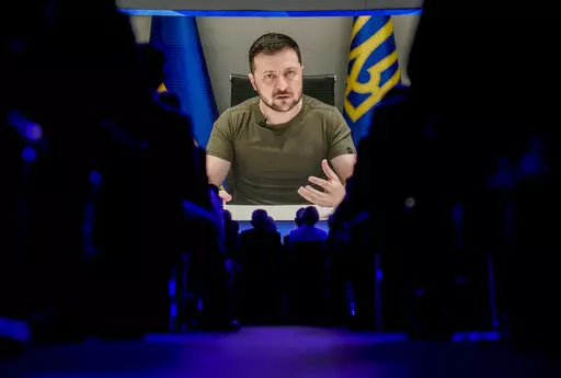 Ukrainian President Volodymyr Zelenskyy displayed on a screen as he addresses the audience from Kyiv on a screen during the World Economic Forum in Davos, Switzerland, Monday, May 23, 2022. The annual meeting of the World Economic Forum is taking place in Davos from May 22 until May 26, 2022. (AP Photo/Markus Schreiber)