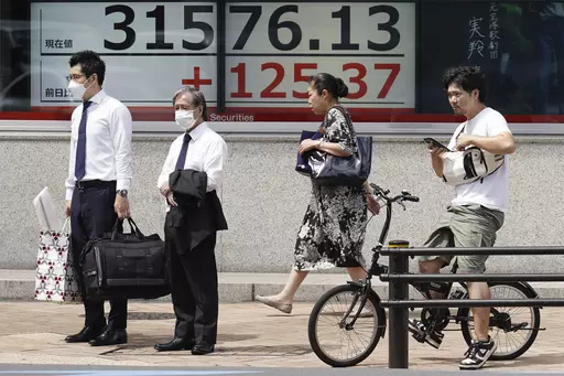 People stand in front of an electronic stock board showing Japan's Nikkei 225 index at a securities firm Monday, Aug. 21, 2023, in Tokyo. Asian stocks were mixed Monday as traders looked ahead to the Federal Reserve’s summer conference for signs of whether the U.S. central bank thinks inflation is under control or more interest rate hikes are needed to cool inflation. (AP Photo/Eugene Hoshiko)