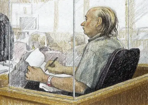This artist's sketch shows accused serial killer Robert Pickton taking notes during the second day of his trial in B.C. Supreme Court in New Westminster, British Columbia, Jan. 31, 2006. Convicted Canadian serial killer Pickton has been hospitalized and is in a life-threatening condition after an assault at a Quebec prison, authorities said Tuesday, May 21, 2024. (Jane Wolsack/The Canadian Press via AP)