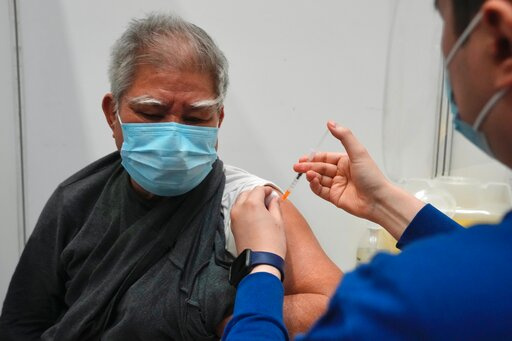 Hui Ngai-seng, 75, receives his first dose of China's Sinovac COVID-19 coronavirus vaccine at a community vaccination center in Hong Kong, Friday, Feb. 25, 2022. (AP Photo/Kin Cheung)