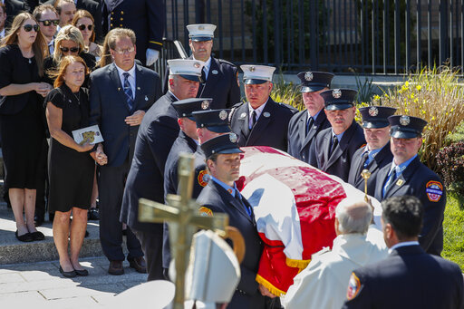 Patrick and Dee Dee Klein, parents of late New York City Firefighter (FDNY) Timothy Klein, follow his casket as it is carried out of St. Francis DeSales Church during a funeral service, Friday, April 29, 2022, in New York. Klein, 31, died Sunday when flames engulfed the second floor of the home, causing part of the ceiling to collapse. (AP Photo/Eduardo Munoz Alvarez)