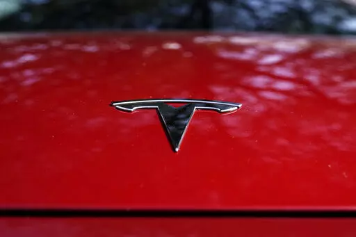 A Tesla logo is seen on a vehicle on display in Austin, Texas, Wednesday, Feb. 22, 2023. On Wednesday, March 1, Tesla executives said the company will use innovative manufacturing techniques and smaller factories to cut the cost of its next generation of vehicles by as much as half of the ones it now builds. (AP Photo/Eric Gay, File)