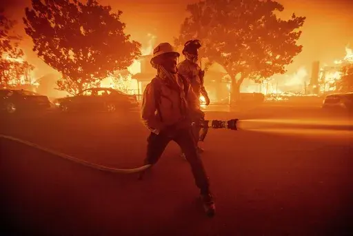 Firefighters battle the Palisades Fire as it burns multiple structures in the Pacific Palisades neighborhood of Los Angeles, Tuesday, Jan. 7, 2025. (AP Photo/Ethan Swope, File)