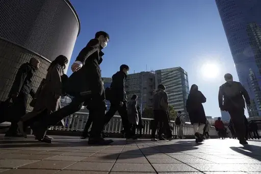 Commuters walk in a passageway during a rush hour at Shinagawa Station, Feb. 14, 2024, in Tokyo. (AP Photo/Eugene Hoshiko, File)