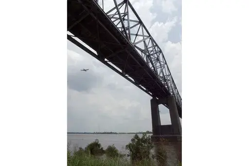An agricultural airplane flies near the Highway 49 bridge over the Mississippi River near Helena, Ark., on June 10, 2004. (AP Photo/Danny Johnston, File)