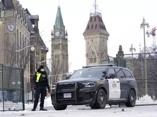 A police officer mans a checkpoint near Parliament Hill, Wednesday, Feb. 23, 2022 in Ottawa. Ottawa protesters who vowed never to give up are largely gone, chased away by police in riot gear in what was the biggest police operation in the nation’s history.  (Adrian Wyld /The Canadian Press via AP)