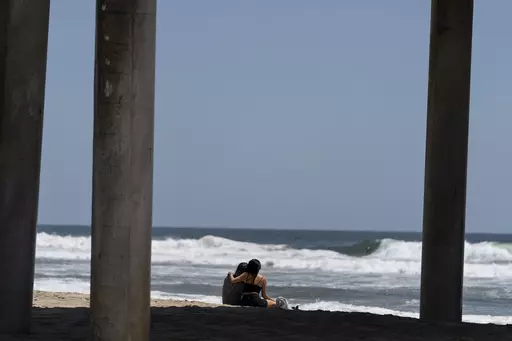A young couple sit on the beach in Huntington Beach, Calif., Monday, May 8, 2023. For years, studies have shown a decline in the rates of American high school students having sex. That trend continued, not surprisingly, in the first years of the pandemic, according to a recent survey by the Centers for Disease Control and Prevention. The study found that 30% of teens in 2021 said they had ever had sex, down from 38% in 2019 and a huge drop from three decades ago when more than half of teens repo