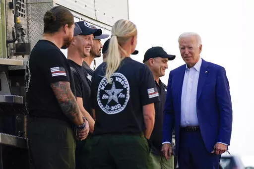 President Joe Biden greets firefighters as he tours the National Interagency Fire Center, Sept. 13, 2021, in Boise, Idaho. Biden on June 21, 2022, signed off on giving federal wildland firefighters a hefty raise for the next two fiscal years, a move that comes as much of the West is bracing for a difficult wildfire season. (AP Photo/Evan Vucci, File)
