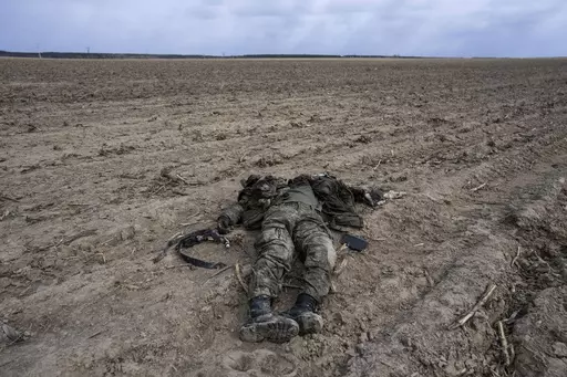 A Russian soldier killed during combats against Ukrainian army lies on a corn field in Sytnyaky, on the outskirts of Kyiv, Ukraine, Sunday, March 27, 2022. Nearly 50,000 Russian soldiers have died in the war in Ukraine, according to a new statistical analysis. (AP Photo/Rodrigo Abd, File)