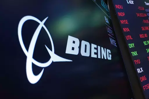 The logo for Boeing appears on a screen above a trading post on the floor of the New York Stock Exchange, July 13, 2021. Boeing says the head of its 737 jetliner program is leaving the company immediately, paving the way for the aircraft maker to appoint new leadership at the troubled division. (AP Photo/Richard Drew, File)