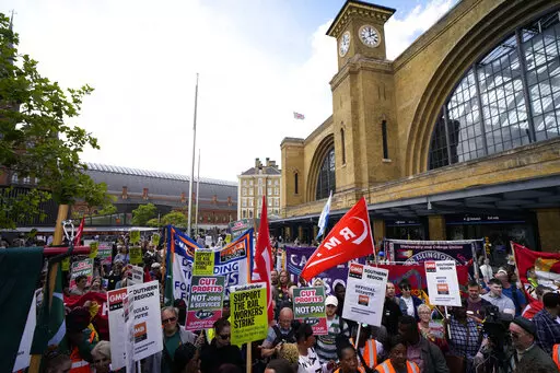 People holds banners and placards as they attend a RMT (The National Union of Rail, Maritime and Transport Workers) union train strike rally outside King's Cross railway station, in London, June 25, 2022. Across Europe, soaring inflation is behind a wave of protests and strikes that underscores growing discontent with spiralling living costs and threatens to unleash political turmoil. (AP Photo/Matt Dunham, file)