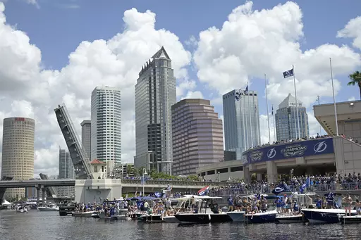 Tampa Bay Lightning fans watch from boats with the downtown skyline in the background during the NHL hockey Stanley Cup champions' boat parade, July 12, 2021, in Tampa, Fla. On Thursday, Dec. 21, 2023, the city of Tampa reached an agreement with the federal government to resolve a discrimination lawsuit alleging that male workers didn't receive the same parental leave as female workers. (AP Photo/Phelan M. Ebenhack, File)