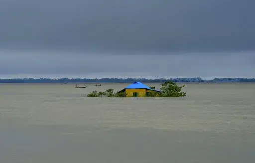 A house stands surrounded by floodwaters in Sylhet, Bangladesh, Monday, June 20, 2022. Early and strong monsoon rains have brought heavy flooding to northeastern India and Bangladesh, killing dozens of people, forcing hundreds of thousands from their homes and cutting millions off from crucial supplies. (AP Photo/Mahmud Hossain Opu)