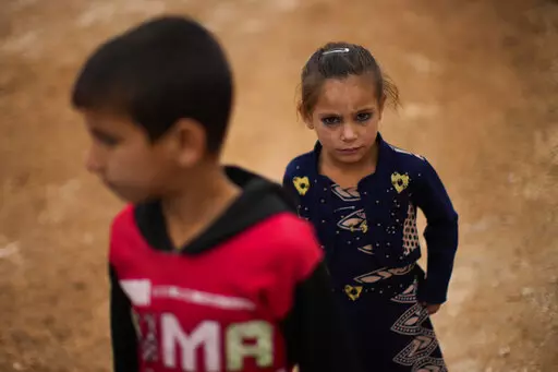 Syrian children wait for donated toys and food to be distributed in a refugee camp for displaced people supported by the Turkish Red Crescent in Sarmada, north of Idlib city, Syria, Thursday, Nov. 25, 2021. (AP Photo/Francisco Seco)