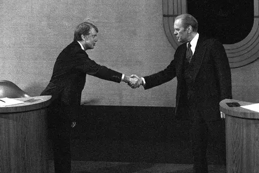 Jimmy Carter, left, and Gerald Ford, right, shake hands before the third presidential debate, Oct. 22, 1976, in Williamsburg, Va. (AP Photo/File)